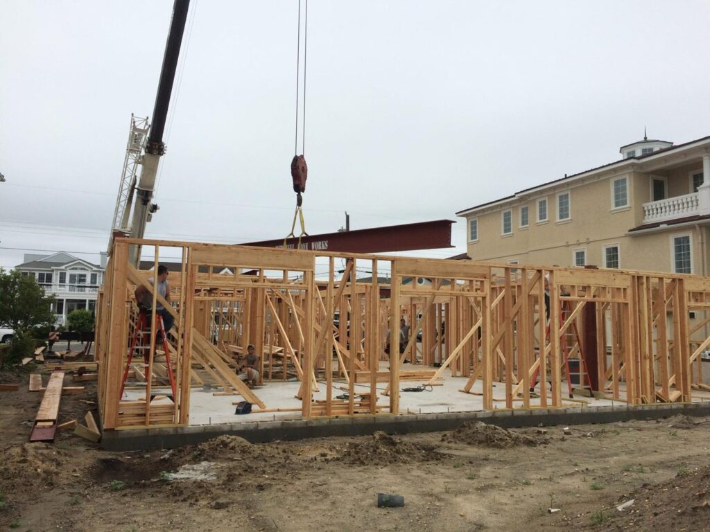 Steel beam on the hook over a framed house