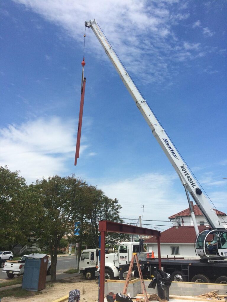 Steel beam on the hook over a framed house