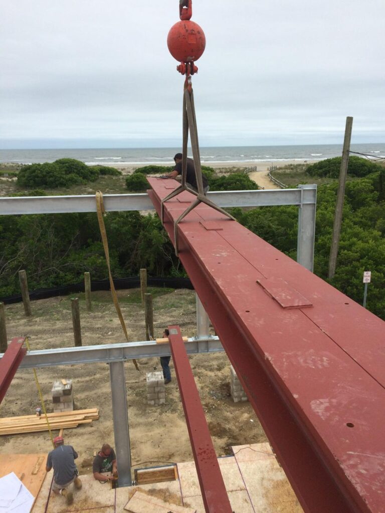 Steel beam on the hook over a framed house