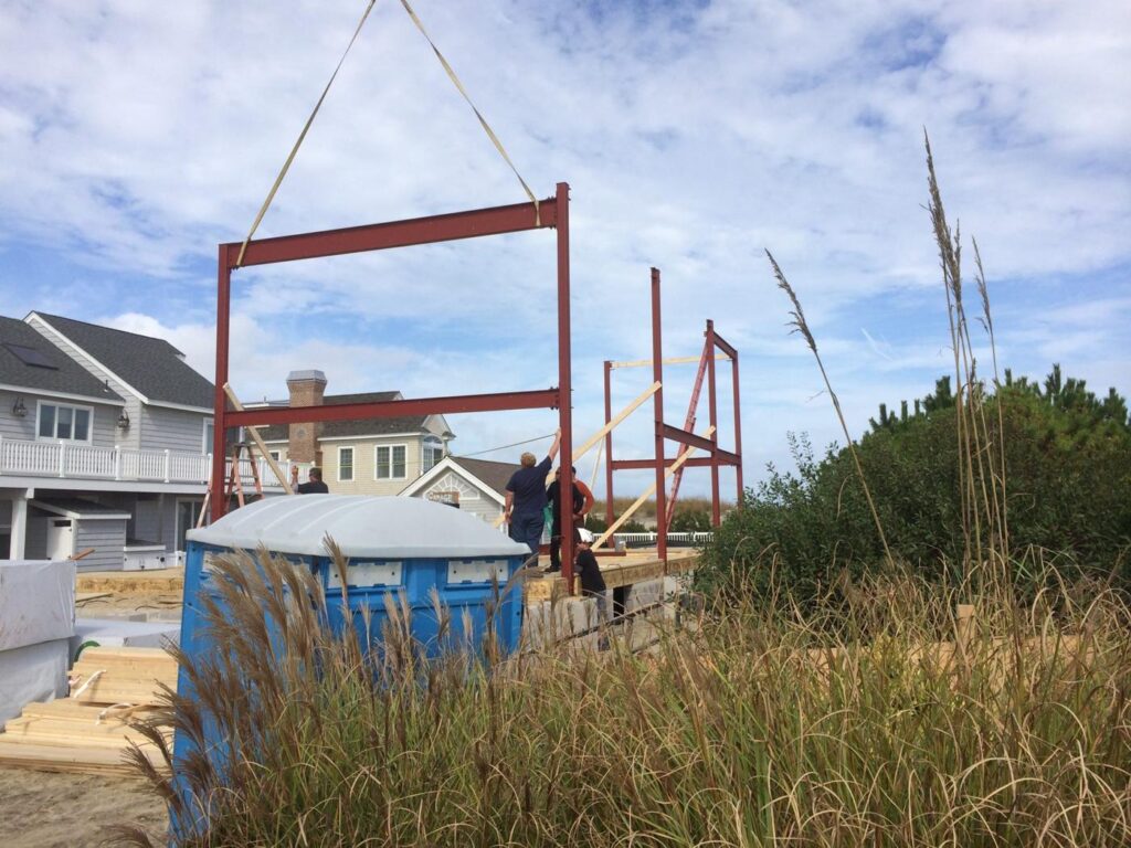 Crane setting a steel frame on a new shore home