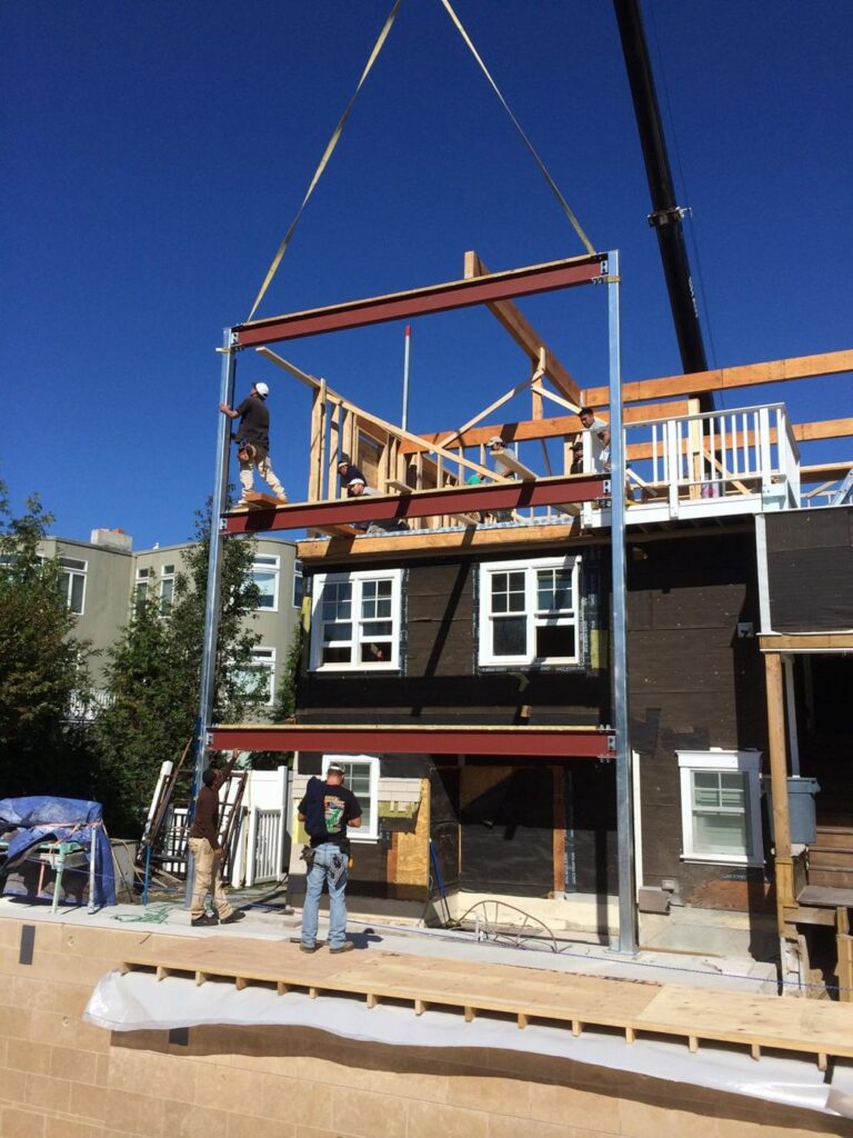 Crane setting a steel frame on a new shore home