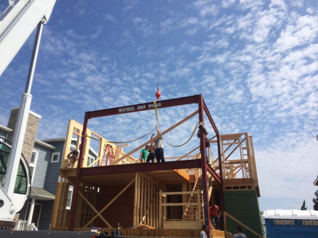 Crane setting a steel frame on a new shore home