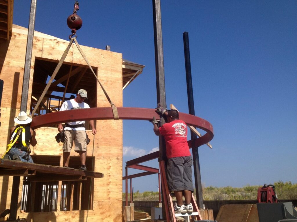 Round steel turret frame lifted into place by crane