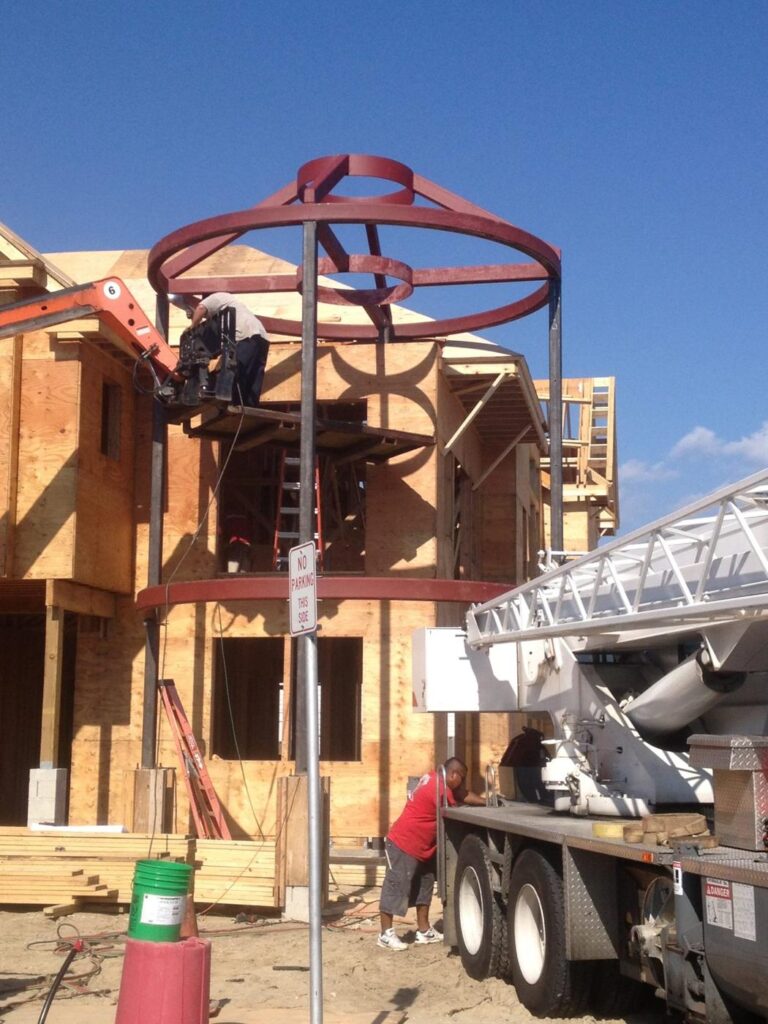 Round steel turret frame lifted into place by crane