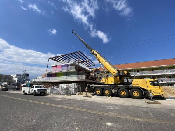 Grove GMK4115 setting steel framing on top of a shore motel