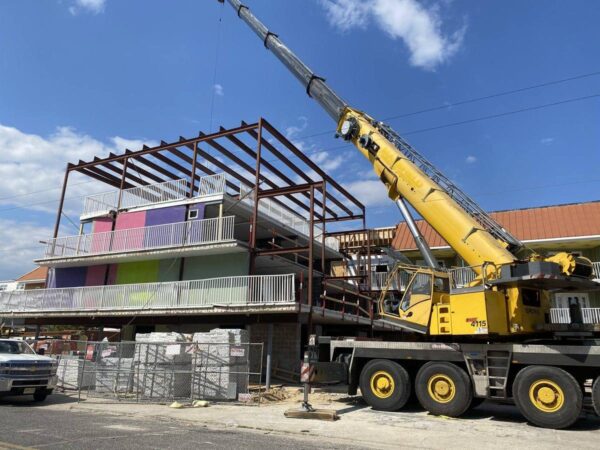 Grove GMK4115 setting steel framing on top of a shore motel