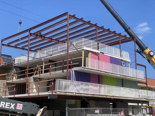 Grove GMK4115 setting steel framing on top of a shore motel