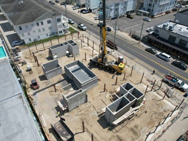 Aerial view of the Grove GMK4115 setting steel columns on a building foundation
