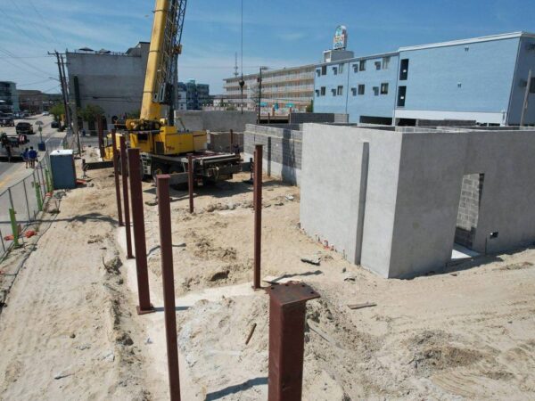 Aerial view of the Grove GMK4115 setting steel columns on a building foundation