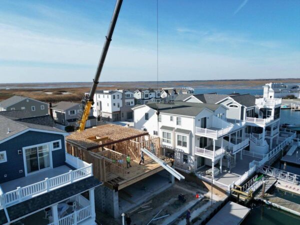 Grove GMK4115 lifting framing onto a lagoon-front home