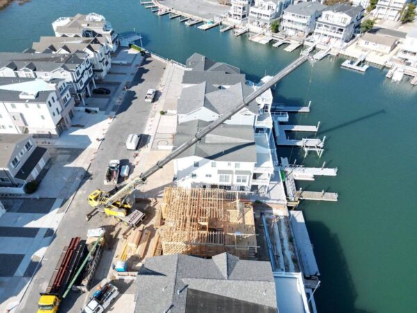 Grove GMK4115 lifting framing onto a lagoon-front home