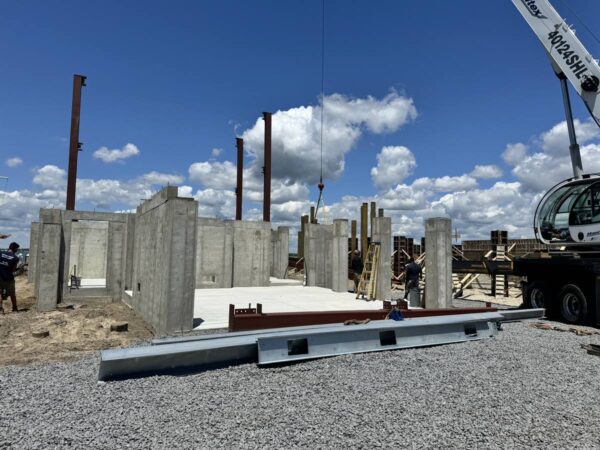 Manitex 40124SHL boom truck setting steel on a concrete foundation