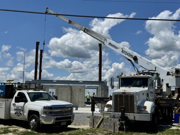Manitex 40124SHL boom truck setting steel on a concrete foundation