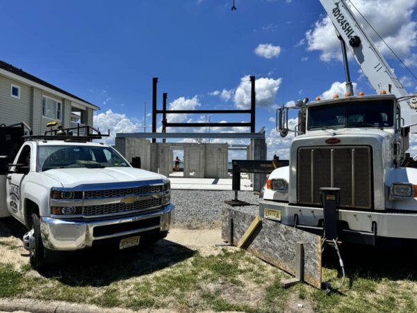 Manitex 40124SHL boom truck setting steel on a concrete foundation