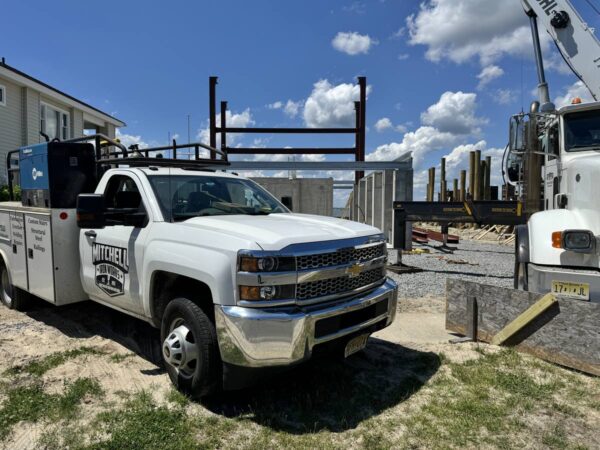 Manitex 40124SHL boom truck setting steel on a concrete foundation