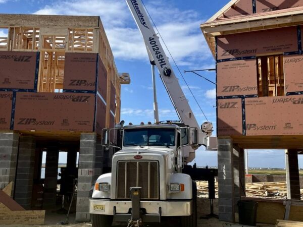 Manitex 40124SHL boom truck setting a steel frame on a shore home