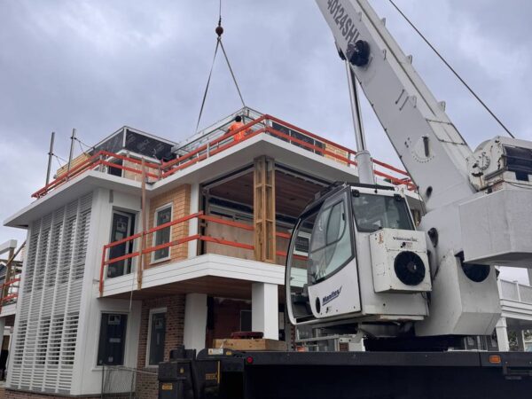 Manitex 40124SHL boom truck setting a steel frame on a shore home