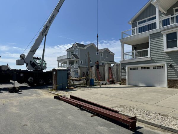 Manitex 40124SHL boom truck setting a steel frame on a shore home